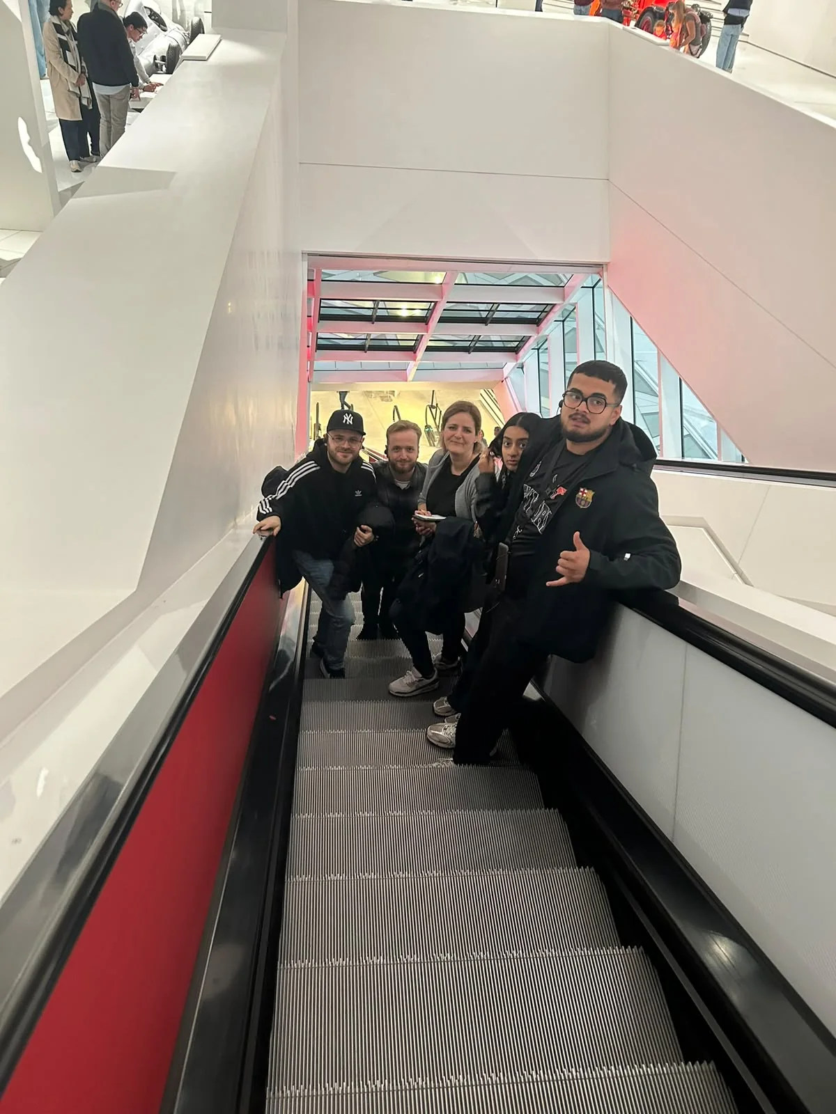 Gruppe des Plauschlagers auf einer Rolltreppe im Porsche-Museum